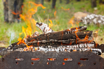 A fire is burning in the grill for cooking.