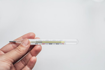 Obraz premium thermometer in hand on a homogeneous background close up