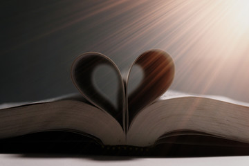 Buch mit Seiten in Herzform wird angeleuchtet