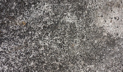 Rough texture of a loft wall made of small black pebbles in gray cement. Photo of a crumbling stone wall made of cement and small stones. Texture overlay with a light background for rough effects.