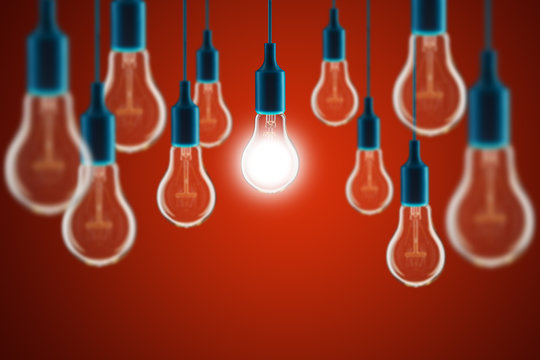 Idea and leadership concept - bulbs on the red background