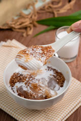 Thai dessert ,Tapioca pearl or Sago pudding with coconut meat in coconut milk on wooden table.