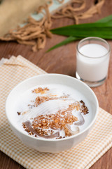 Thai dessert ,Tapioca pearl or Sago pudding with coconut meat in coconut milk on wooden table.