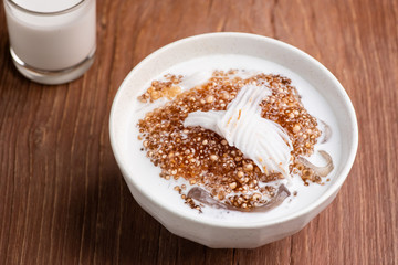 Thai dessert ,Tapioca pearl or Sago pudding with coconut meat in coconut milk on wooden table.