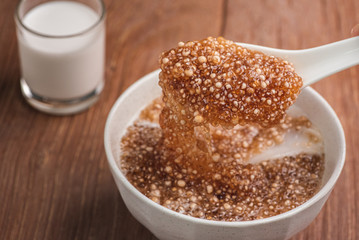 Thai dessert ,Tapioca pearl or Sago pudding with coconut meat in coconut milk on wooden table.