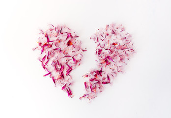A broken heart made of pink flower petals.