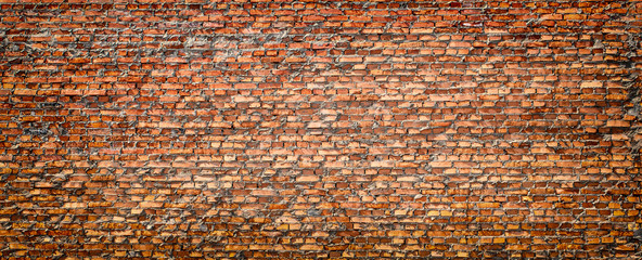 Red brick wall partially destroyed by rain. Texture.