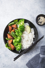 Vegan teryaki  tempeh or tempe buddha bowl  with rice, steamed broccoli, spinach  and lime on gray background. Healthy food