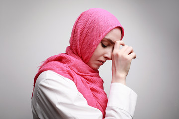 Side view of young muslim woman in hijab praying solated on white background. Woman religious Islam lifestyle concept. 