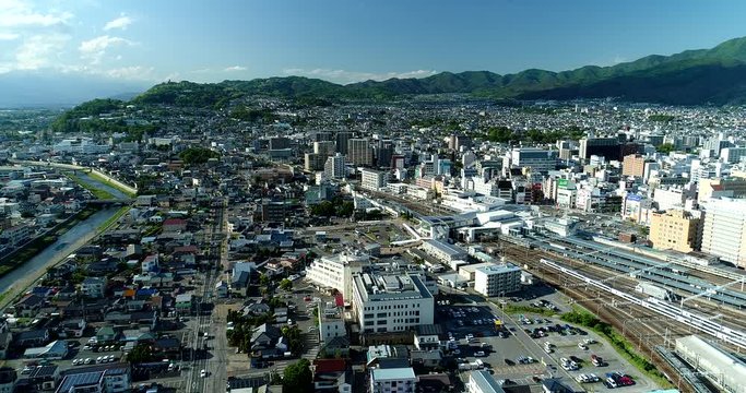 Aerial : Mid size city in Japan. Matsumoto, Nagano. Train station.