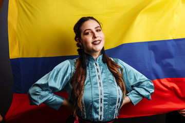 Colombian lady smiling and dancing against national flag of Colombia