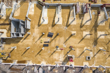 Construction site from above. Aerial view of workplaces in construction equipment, workers with heavy machinery. Industrial top view made by drone.