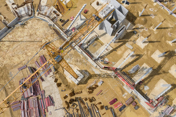 Construction site from above. Aerial view of workplaces in construction equipment, workers with heavy machinery. Industrial top view made by drone.