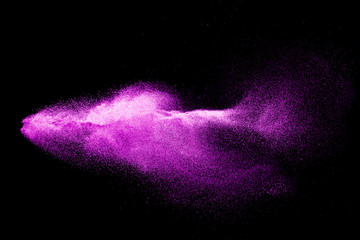 Dry river sand explosion. Purple colored sand splash against  black background.