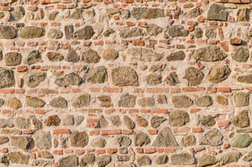 Medieval old wall made of stones and bricks texture and background