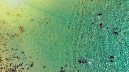Swimmers near the shoreline, downward aerial view
