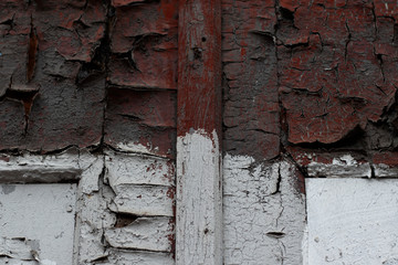 The old wooden door is painted in old cracked and clinging red and white paint. A photo was taken close-up for your grunge design.