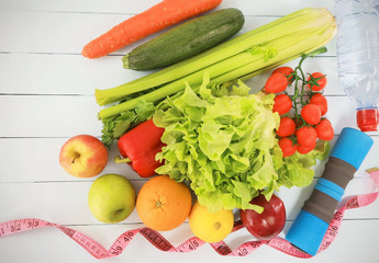 Healthy eating with vegetables and dumbbells promoting a healthy fitness-weight loss  and eating lifestyle concept