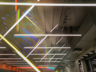 Glowing lamps in prism look hanging under ceiling and ventilation ducts