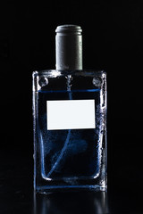Glass perfume in drops on a black blurred background mocap