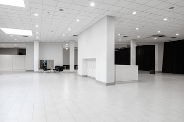 Spacious white industrial space with ceiling and columns. Empty interior.