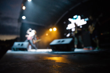 The concert is out of focus. Stage artists in blurry background