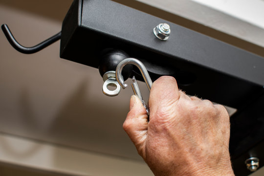 Male Hand Clipping A Carabiner Clip To Gym Equipment Cable Machine At Home