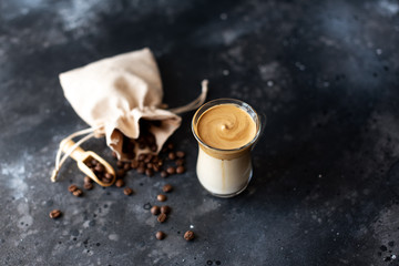 Two glass cups with Dalgona frothy coffee trend korean drink latte espresso with coffee foam on black background