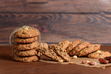 homemade oatmeal cookies with dates, peanuts, coconut shavings on a wooden background, macro close-up. broken cookies in the foreground. space for text