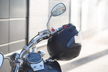 Motorcycle steering wheel and dashboard on the street with a helmet.