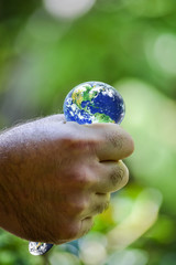 hand squeezing planet earth, human hand holding planet earth