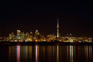 View over Auckland harbour at Auckland CBD skyline at night.