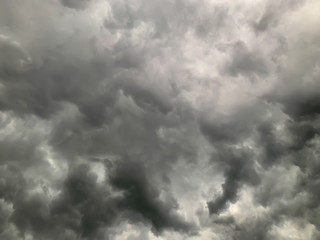 Obraz premium Black clouds formed before the rain, used for make a background image. Clouds become dark gray like a big smoke before rainfall. Thunderstorm is a storm with lightning and thunder.