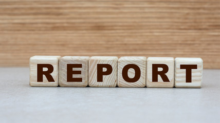 concept of the word REPORT on cubes on a wooden background