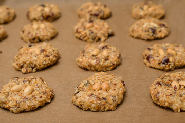homemade oatmeal cookies with dates, peanuts , coconut shavings on a baking tray, close-up. the view from the top