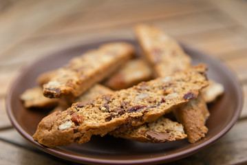 Homemade Biscotti with nuts and dried fruit on a brown plate
