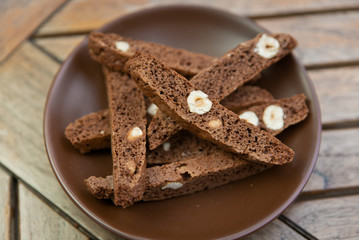 chocolate Homemade biscotti with nuts on a brown plate on a wooden table