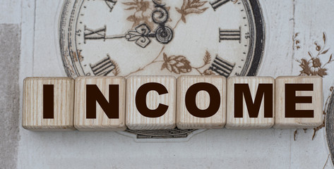 INCOME word on cubes on a background of drawn vintage watches