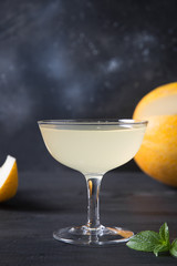 Melon lemonade in wine glass on dark background. Close up. Vertical format.