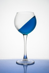 Blue ice drink in a glass is frozen at an angle on a white background