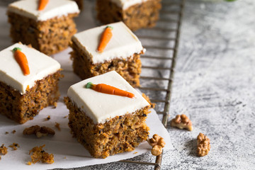 pieces of carrot cake with walnuts with icing cream on a light background. tinting. selective focus