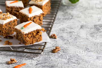 pieces of carrot cake with walnuts with icing cream on a light background. tinting. selective focus