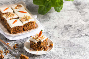 pieces of carrot cake with walnuts with icing cream on a light background. tinting. selective focus