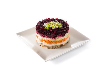 Traditional Russian herring salad with beetroot and carrots isolated on white background. 