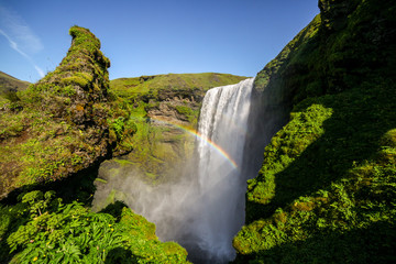 Icelandic waterfall Skogafoss with a rainbow and green moss. Icelandic waterfall. Skogafoss...