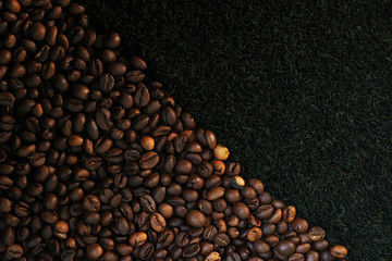 Coffee grains and black loose tea background. Coffee or tea, drink concept