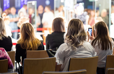 Anonymous audience listens to the speech of the lecturer in the conference hall