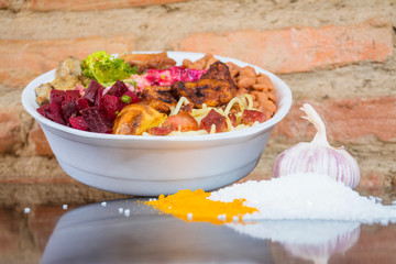 Deliver food, marmita ou marmitex with rice, beans, beets, broccoli, mayonnaise with vegetables, fried chicken, beef stroganoff, pasta and bacon on a dark marble table.