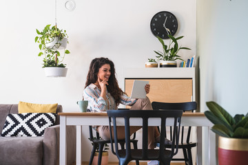 Fototapeta premium Woman laughing while looking at tablet stock photo