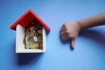 A replica house with a coins and a hand. Conceptual moratorium package as financial assistance...